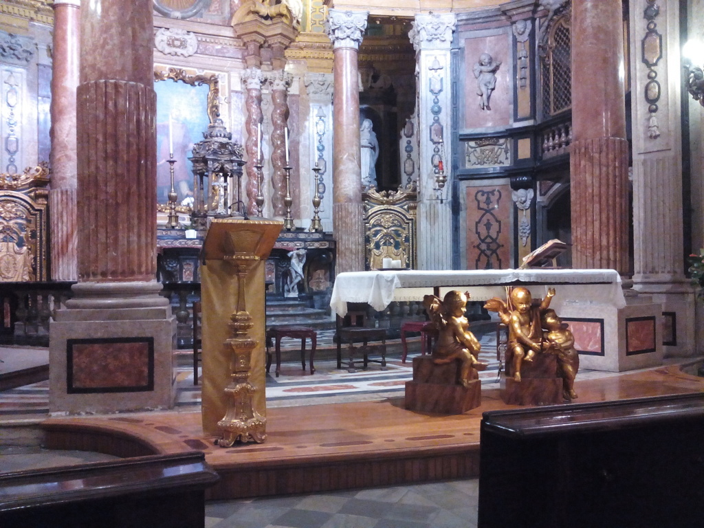 La barocca Real chiesa di S. Lorenzo in Torino è opera di Guarino Guarini, eseguita negli anni tra il 1668 e il 1687. L-adeguamento liturgico propone un prolungamento della pedana presbiterale in legno con leggio sulla sinistra dello altare, elaborati entrambi in forme coerenti col barocco e leggere, per contenere lo impatto visivo.