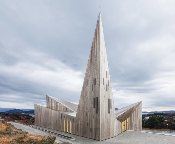 La vista dall’alto mostra l’articolazione a cuspodi e diedri della copertura, su cui spicca a sinistra dell’ingresso un vertice maggiore, a mo’ di campanile. (RRA_Knarvik-©Hundven-Clements_Photography)